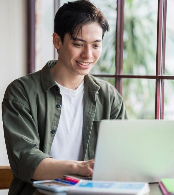 Young Asian virtual legal assistant working on a laptop at a coffee shop